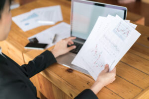 business woman hand with financial charts laptop table